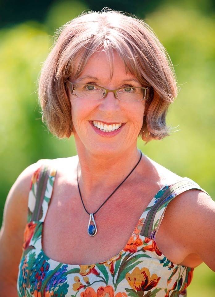 Elisabeth Vismans, Art Instructor, looking and smiling to the camera dressed in a colorful sundress.