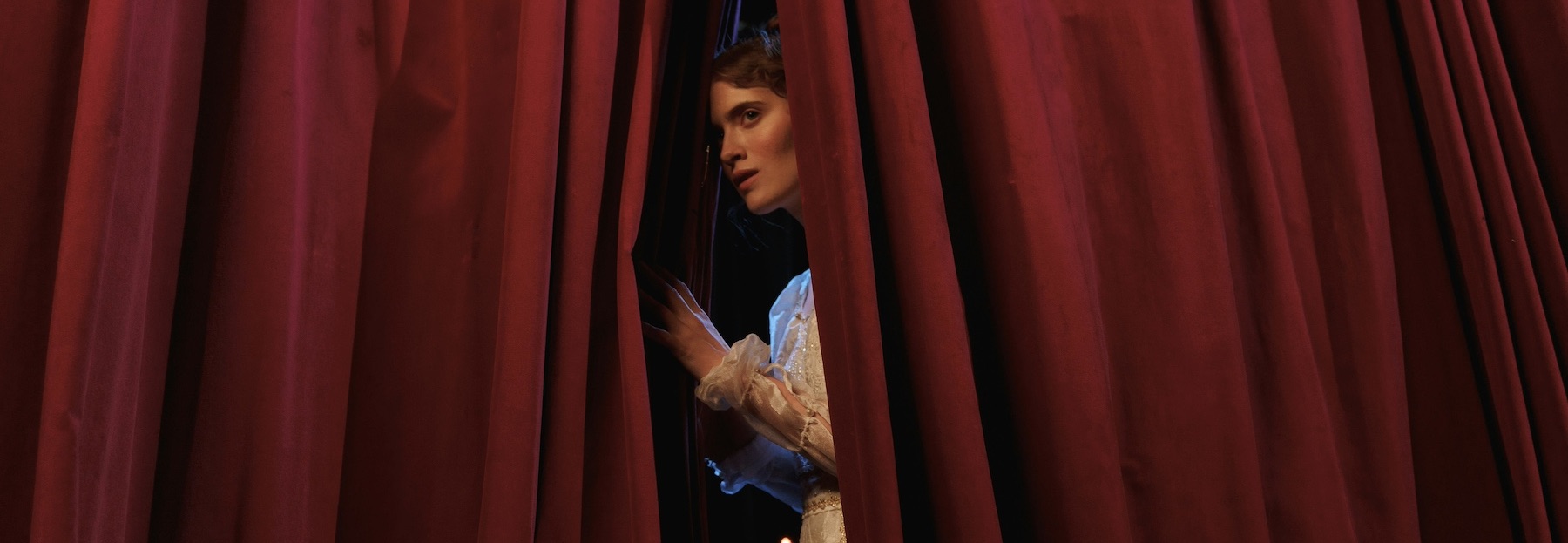 actor takes a sneak peek through the curtains at the public