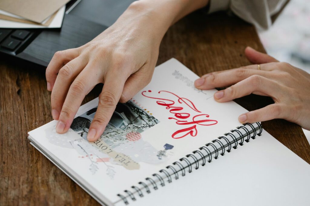 Hands glueing a photo on a journal page