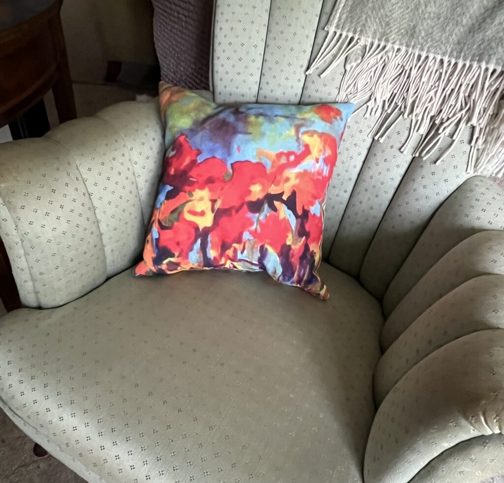 Small pillow with the print of a painting by Elisabeth Vismans on a chair.