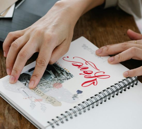 Hands glueing a photo on a journal page